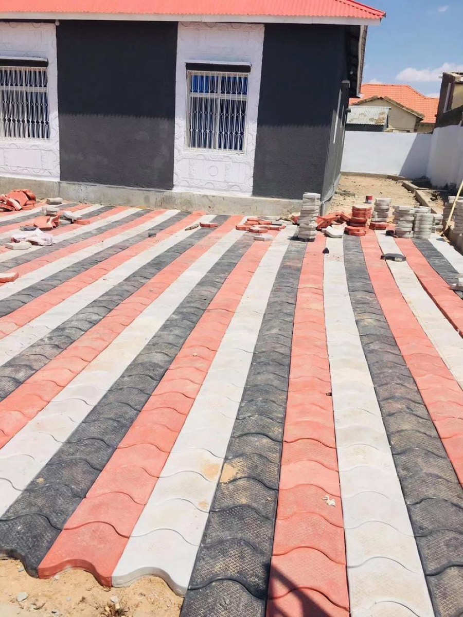 Yard paved in red, white and grey stripes